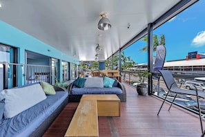 A modern outdoor seating area with a sofa, chairs, and a wooden table.