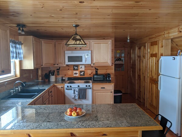 Enjoy cooking in this well-appointed kitchen with a microwave, stove, and sink, plus a convenient window and door leading to the outdoors.