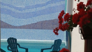 A pool area with blue chairs and a view of a mosaic wall. - La Casita (Antigua)