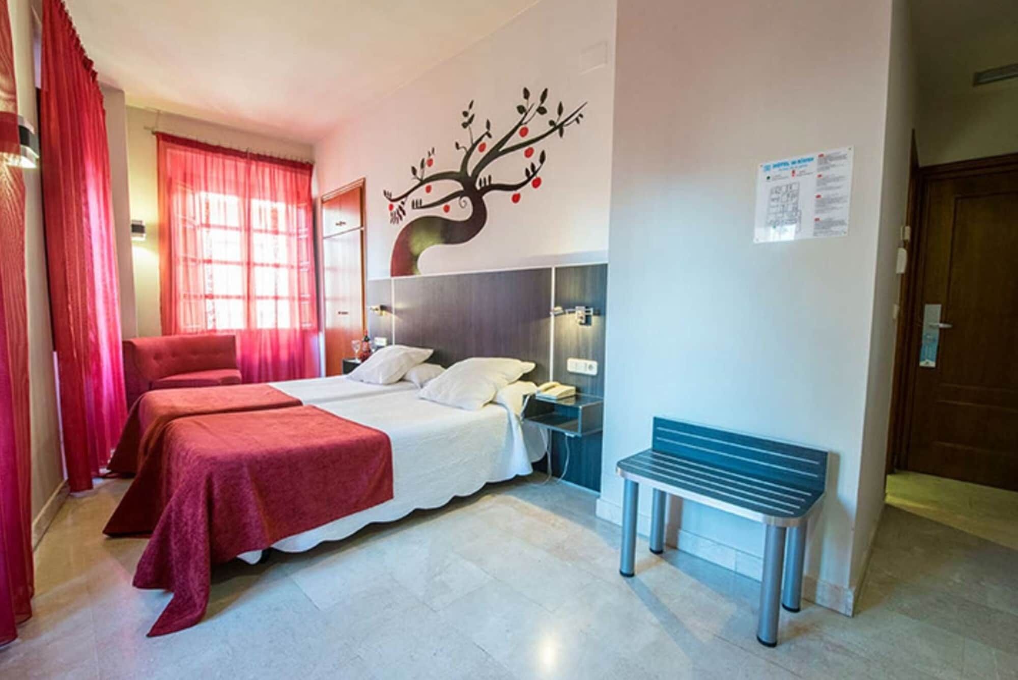 Habitación de hotel con dos camas, un banco, una mesita de noche y un adorno en la pared.
