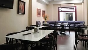 A dining area with a white table and chairs, a sofa, and a TV mounted on the wall. - Las Nieves (Granada)
