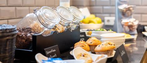 Disposición de bufé con diversos alimentos y recipientes.