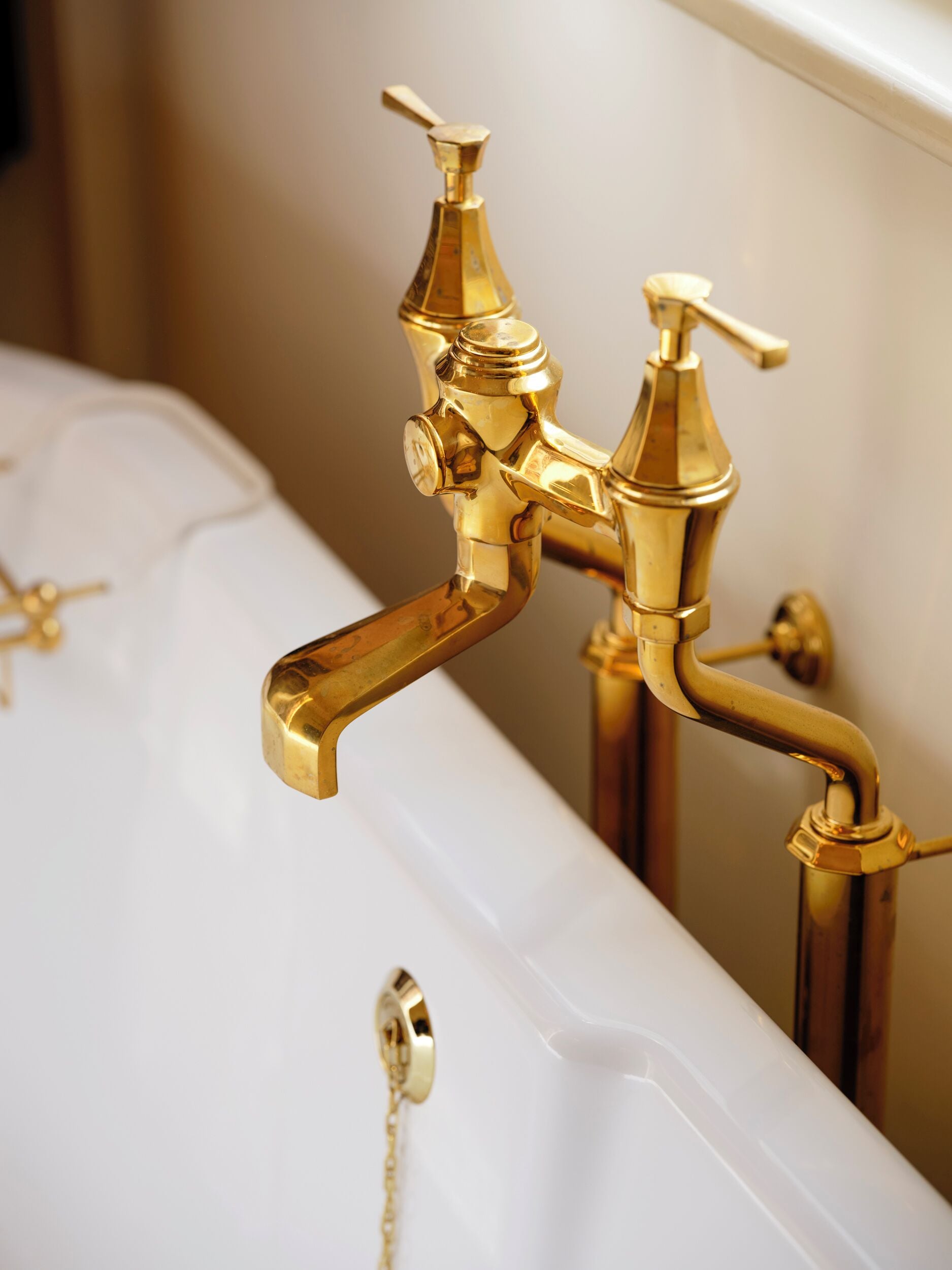 Eine Badewanne mit goldenen Armaturen und weißem Innenraum.