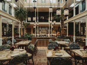 A spacious, elegantly designed hotel lobby with high ceilings, ornate columns, and a central bar area. - NoMad London (London)