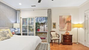 Une chambre à coucher avec un lit, une chaise, une commode, une lampe et un tableau.