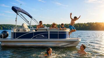 A pontoon boat with a canopy, seating, and a logo.