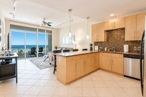 Una cocina moderna con una isla grande, armarios de madera y vistas al exterior.