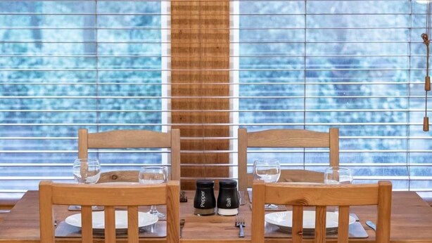 Une table à manger avec deux chaises en bois, un salier et un poivrier, et un verre sur chaque chaise.