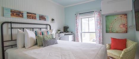 A bedroom with a bed, a desk, and a chair.
