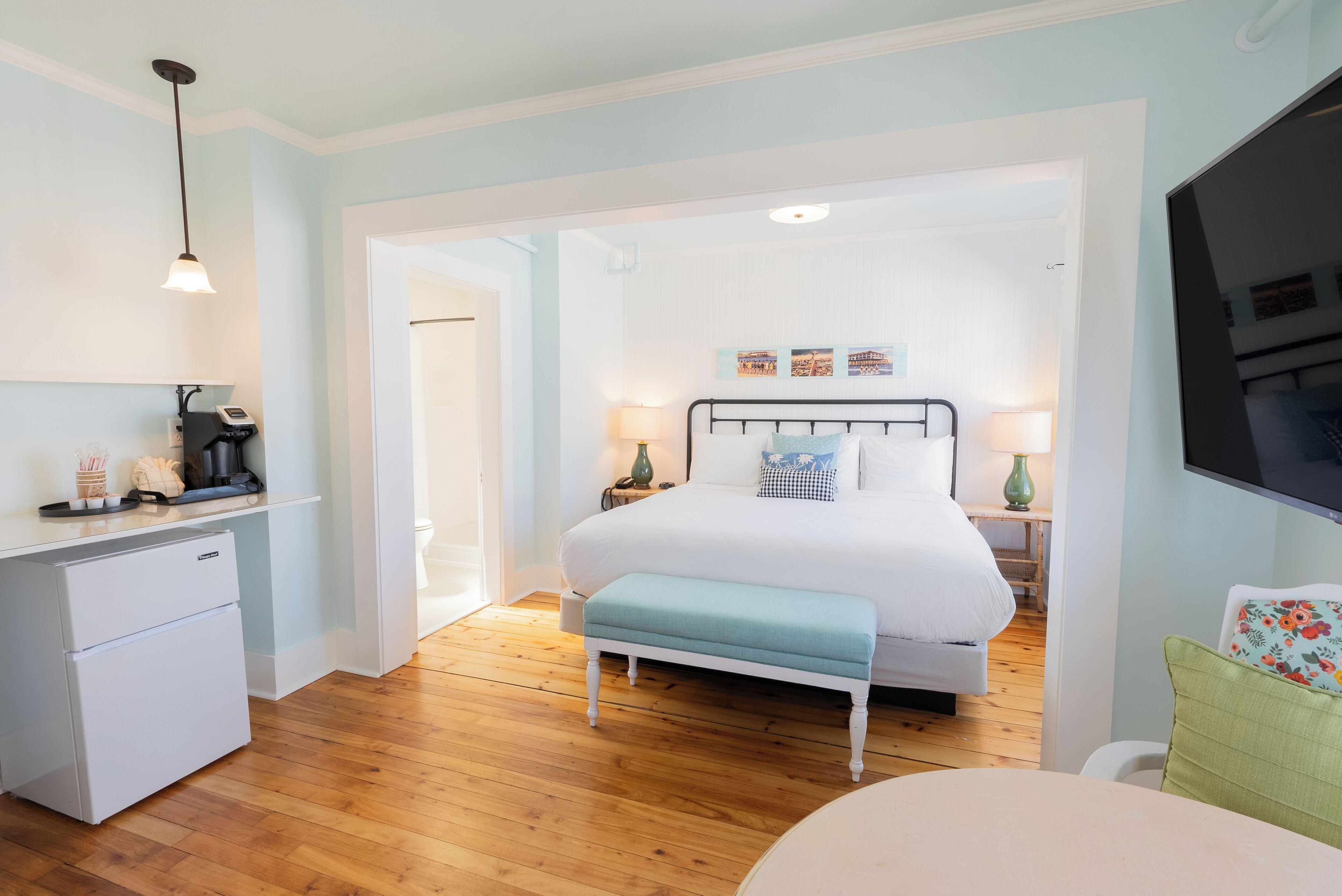 A bedroom with a bed, bedside tables, a desk, and a chair.