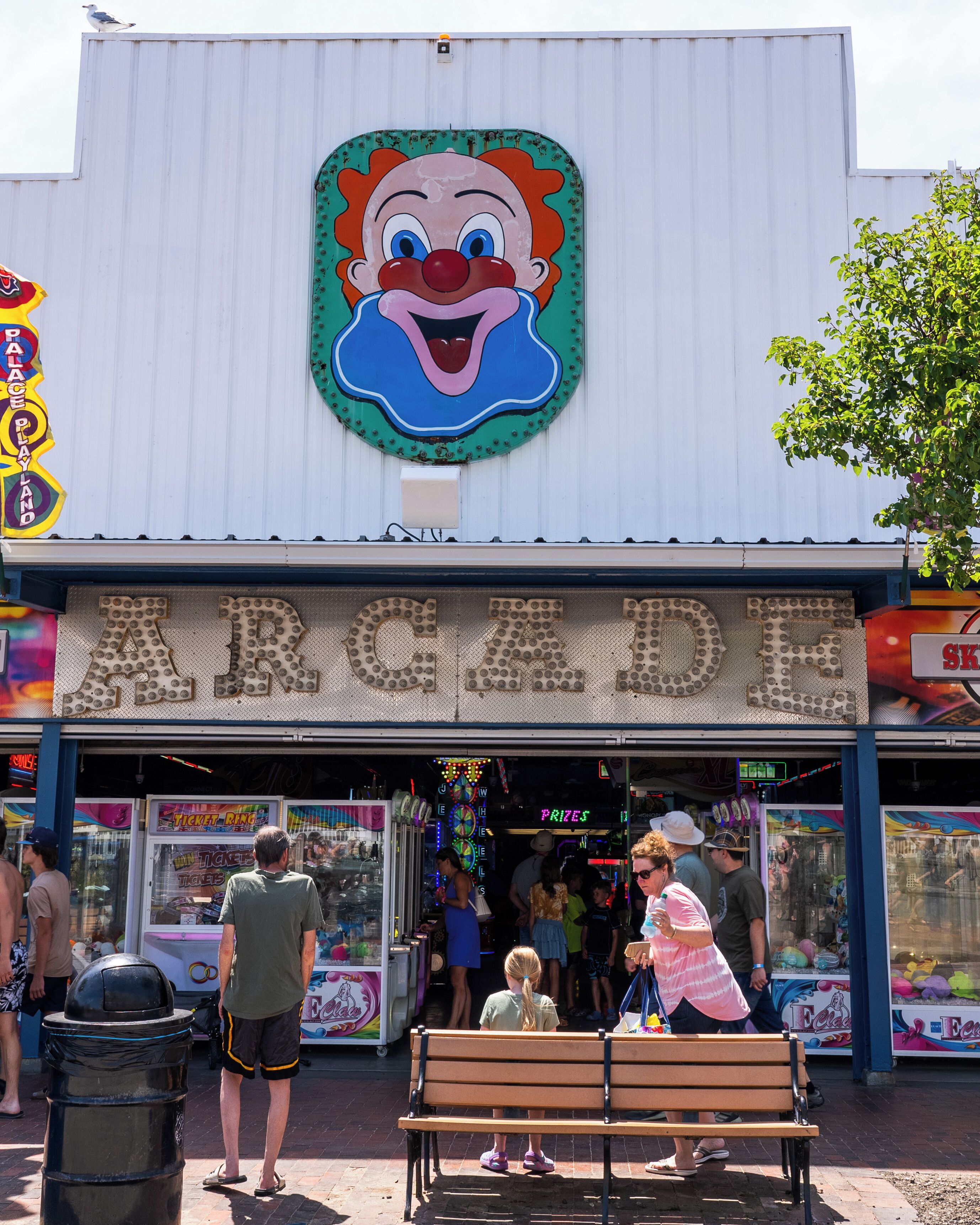 A building with a large cartoon clown face on the facade and the word "ARCADES" below.