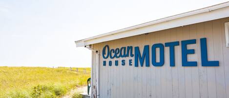 A white building with the sign "Ocean Motel" in blue letters.