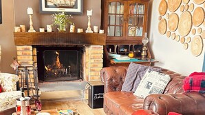 A cozy living room with a fireplace, leather sofa, wooden coffee table, and a bookshelf. - House With Direct Sea Access On 18000 M2 Of Woodland (Argol)