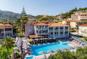 A hotel with a swimming pool, multiple balconies, and a view of the surrounding landscape. - Anamar Zante Hotel (Zakynthos)