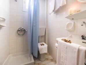 Un baño con bañera, inodoro, lavamanos y cortina de ducha.