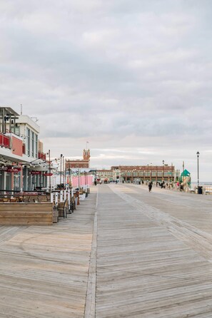 A boardwalk with shops and a building in the background. - The Melrose, 2B - Double Bed & Bath: Romantic Geta (Neptune Township)