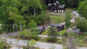 A lakeside property with multiple cabins, a main house, and a dock. - Newfound Lake Bristol, NH Lakefront Cottage (Bristol)