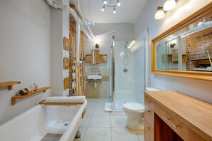 A modern bathroom with a bathtub, toilet, and shower. - Les Lofts St-Jo - By Les Lofts Vieux-Québec (Québec City)