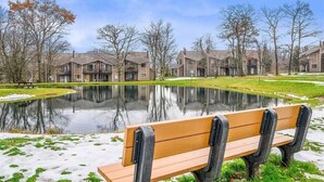 A residential area with a pond, benches, and houses. - Cozy Mountain Retreat (Hidden Valley)