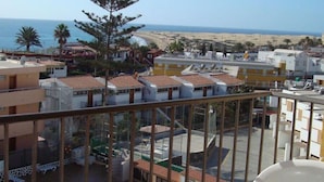 Un quartier résidentiel situé sur la côte, avec des immeubles, une plage et une vue dégagée sur la mer.