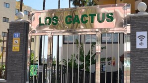 Une entrée fermée par un portail, sur laquelle on peut lire l’inscription « LOS CACTUS ».