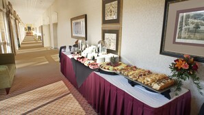 Una mesa de buffet con diversos alimentos y un arreglo floral.