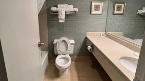Un baño con inodoro, lavamanos y perchero para toallas.