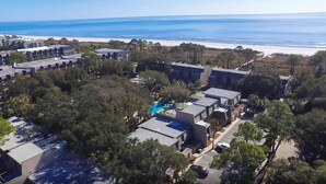 An aerial view of a resort with multiple buildings, a swimming pool, and a beach in the background. - Ocean Club Villa steps from the beach, minutes away from Coligny Plaza! (Hilton Head Island)