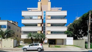 Un immeuble à plusieurs étages, doté d’un élément vertical central, vraisemblablement un escalier ou un puits d’ascenseur, et entouré de balcons.