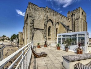 A historic stone building with arched windows and a balcony with potted plants. - Mercure Avignon Centre Palais des Papes Hotel (Avignon)