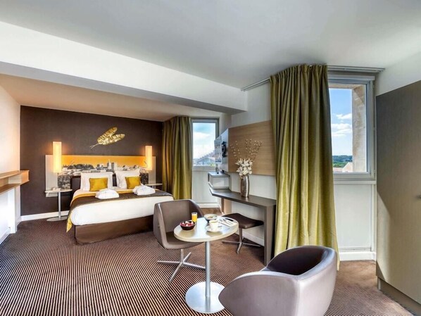 A hotel room with a bed, a desk, a chair, a small table with breakfast items, and a view of the outdoors. - Mercure Avignon Centre Palais des Papes Hotel (Avignon)