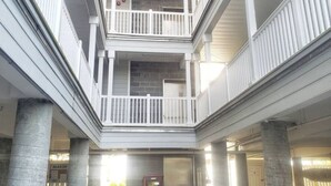 A multi-level atrium with white railings and concrete pillars.