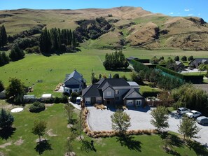 A large house with a spacious driveway and a well-maintained lawn.