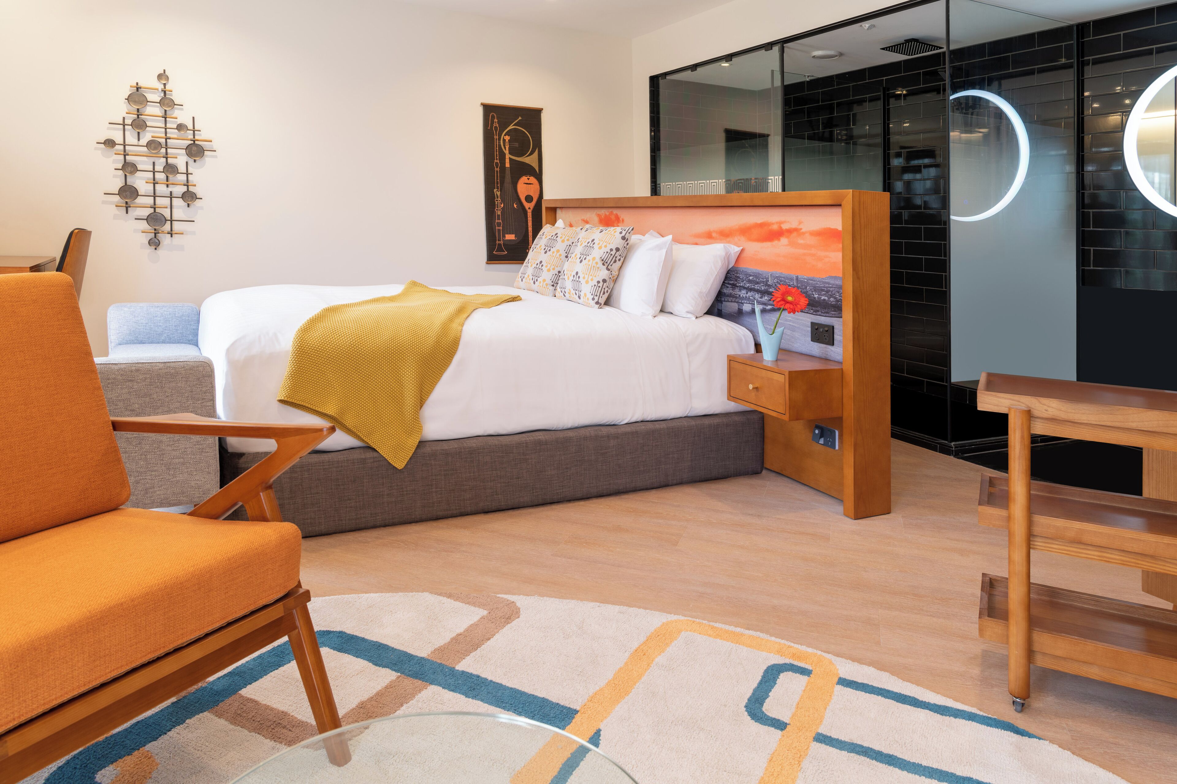 Una habitació d'hotel moderna amb un llit, una taula de treball i una cadira.