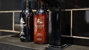 Deux bouteilles de gel douche Marihi sur le comptoir d’une salle de bain.