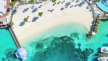 On the beach, white sand, beach cabanas, sun-loungers