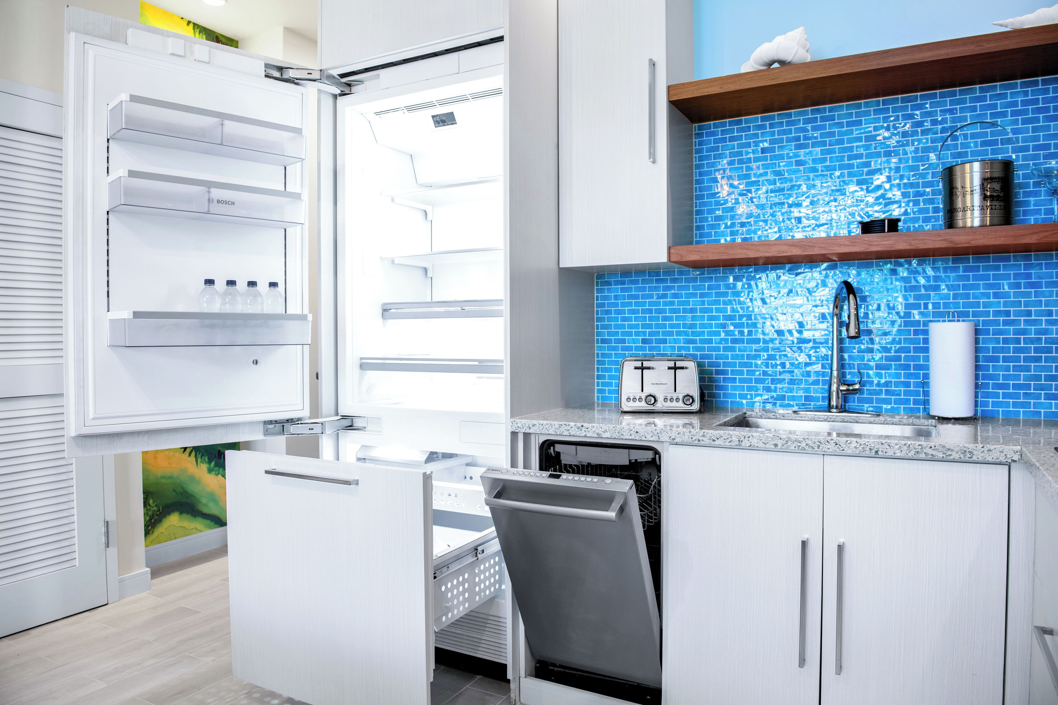 Cozinha moderna com geladeira Bosch embutida, lava-louças Bosch e uma torradeira na bancada.