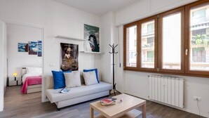 Una sala de estar moderna con un sofá blanco, una mesa de centro y obras de arte en las paredes.