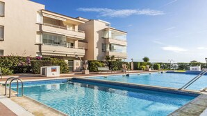 Ein modernes Hotel mit Poolbereich, inklusive zwei Schwimmbecken und einer Sonnenterrasse.