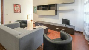 A modern living room with a grey sofa, black armchairs, a coffee table, and a flat-screen TV on a wooden cabinet. - Beautiful  villa for 4 guests with WIFI, TV and pets allowed (Castelveccana)