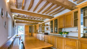 Un'ampia cucina con armadietti in legno e un lungo bancone.
