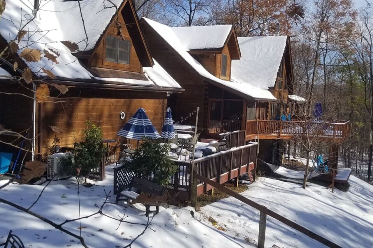Una cabaña de madera con terraza y zona de estar al aire libre.