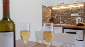 Una cocina moderna con un salpicadero de piedra, un fregadero y una tetera sobre la encimera.
