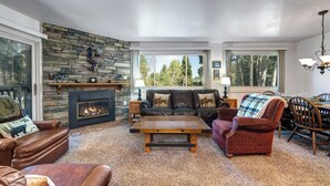 A cozy living room with a stone fireplace, leather sofas, and a dining area with a table and chairs. - Managed by Park City Lodging-True Ski-In/Ski-Out to Park City Mountain Resort! (Park City)