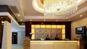 A hotel reception area with a large chandelier, a reception desk, and a decorative wall with patterned tiles. - Jiayue Hotel (Shenzhen)