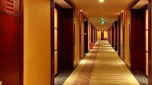 A hotel corridor with a carpeted floor, wooden doors, and a long hallway. - Jiayue Hotel (Shenzhen)