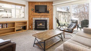 Una sala de estar acogedora con chimenea, televisor y un área de estar confortable.