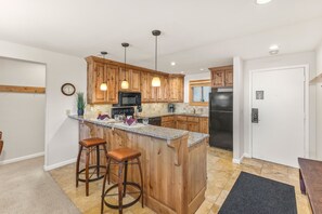 Enjoy cooking in this well-equipped kitchen with a central island and bar stools.