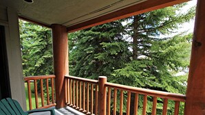 A wooden balcony with a railing, two green Adirondack chairs, and a small table. - True Ski-In/Ski-Out to Park City Mountain Resort I Managed by Park City Lodging (Park City)