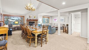 A spacious living room with a dining area, large windows, and a fireplace. - True Ski-In/Ski-Out to Park City Mountain Resort I Managed by Park City Lodging (Park City)